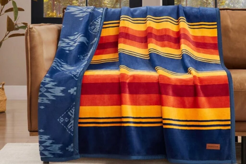 Costco x Pendleton reversible throw blanket in classic Pendleton patterns, folded on a couch
